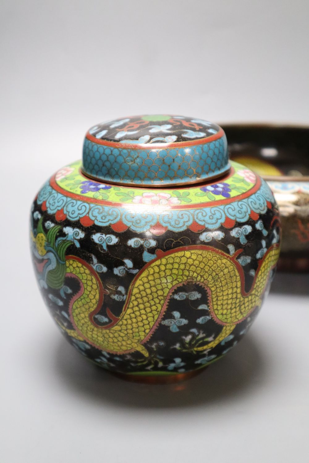 An early 20th century Chinese cloisonne enamel dragon bowl, a similar box and cover and a ginger jar and cover, largest diameter 30cm